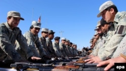 Afghan border police officials swear an oath on the holy Koran during their graduation ceremony in Helmand Province on March 2