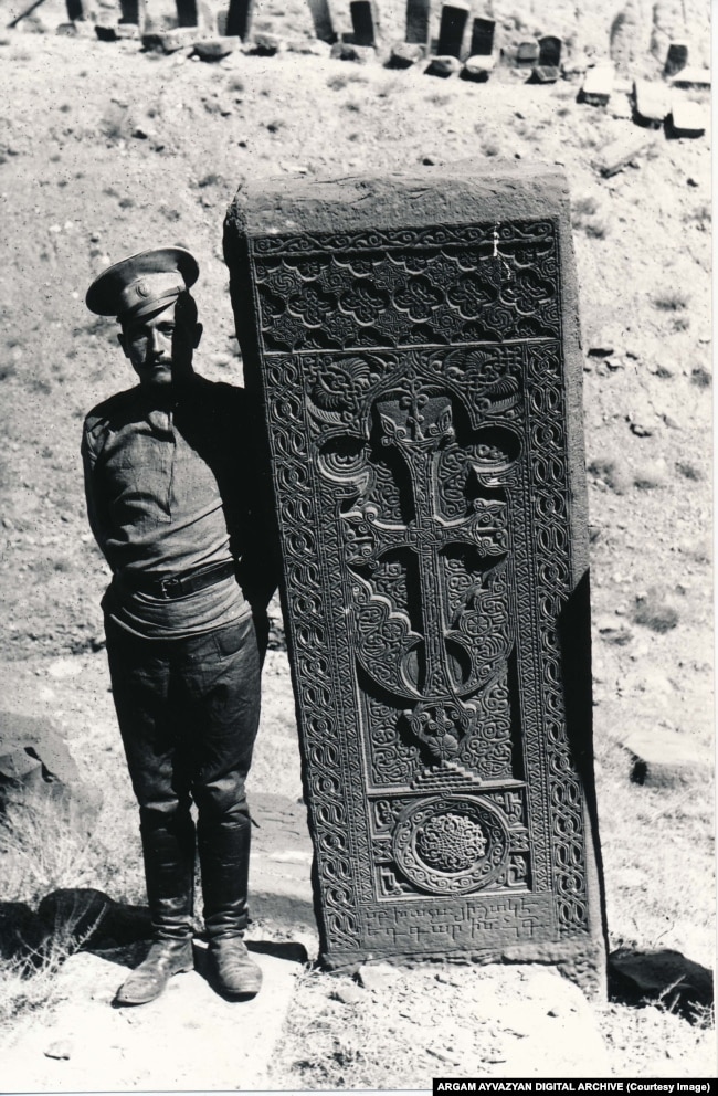 A soldier poses next to a Julfa khachkar in 1915.