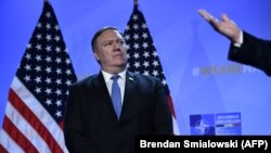 BELGIUM -- U.S. Secretary of State Mike Pompeo (L) looks on as US. President Donald Trump addresses a press conference on the second day of the NATO summit in Brussels, July 12, 2018