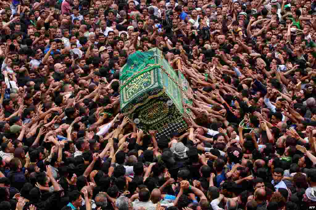 Iraqi Shi'ite Muslim worshippers carry the symbolic coffin of the 8th-century Imam Musa al-Kadhim during a funeral procession on the anniversary of his death at his shrine in Baghdad’s northern district of Kadhimiya. (AFP/Sabah Arar)