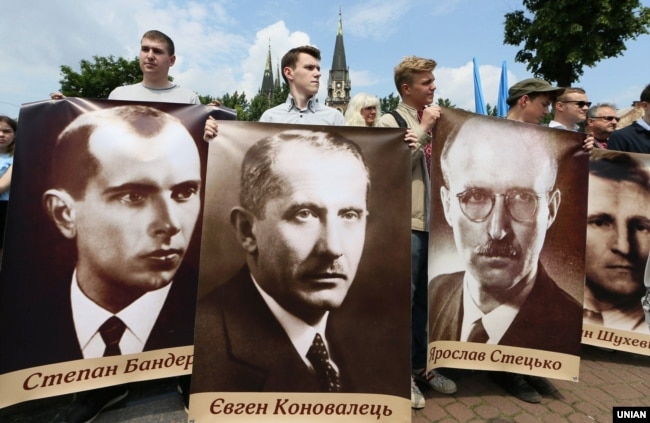 Учасники заходів з нагоди Свята Героїв тримають плакати із зображенням Степана Бандери, Євгена Коновальця, Ярослава Стецька та Романа Шухевича. Львів, 26 травня 2019 року