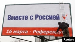 Рабочий устанавливает агитационную рекламу с призывом принять участие в незаконном «референдуме за присоединение Крыма к России» в центре Симферополя, 11 марта 2014 года