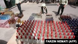 Iranian police prepare to destroy confiscated bottles of alcohol in Tehran.