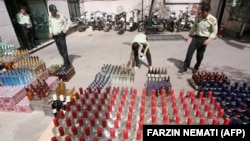 Iranian police prepare to destroy confiscated bottles of alcohol in Tehran. File photo