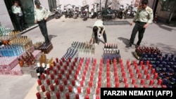 Iranian police prepare to destroy confiscated bottles of alcohol in Tehran.