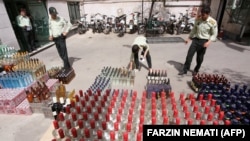 Iranian police prepare to destroy confiscated bottles of alcohol in Tehran.