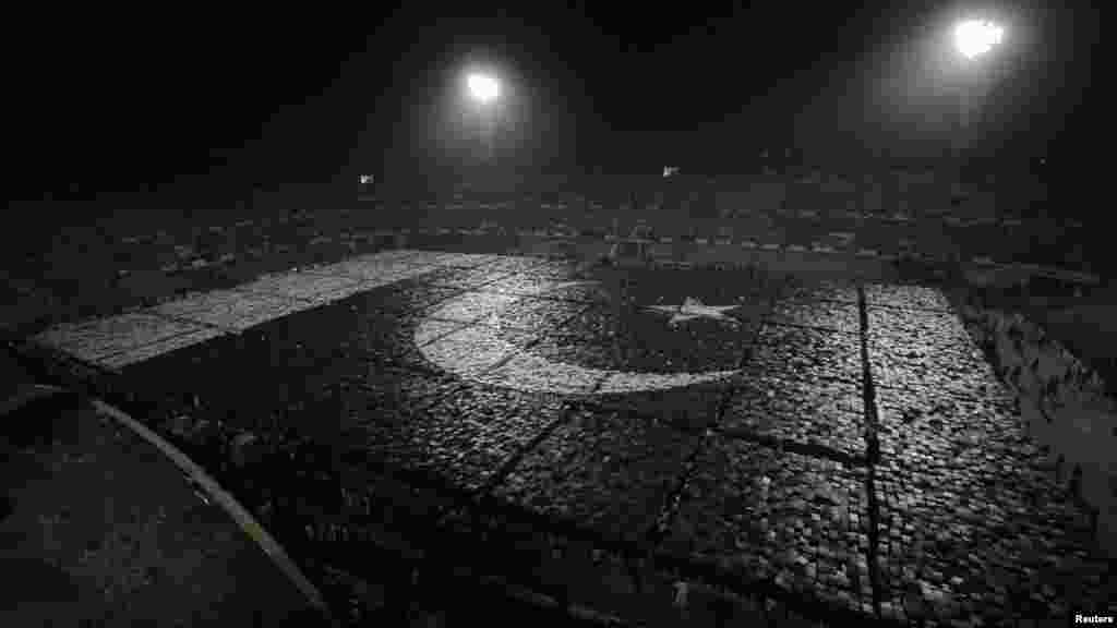 Pakistani students stand together to form the world's largest human flag to qualify for the Guinness World Records at the National Hockey Stadium in Lahore. (Reuters/Mohsin Raza)