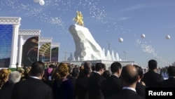 People attend the inauguration of a gilded equestrian statue of Turkmen President Gurbanguly Berdymukhammedov in Ashgabat in May 2015. 