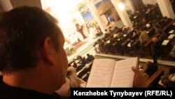 Мужчина держит в руке религиозную книгу на фоне проходящего богослужения. Иллюстративное фото.