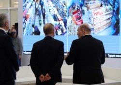 Russian President Vladimir Putin (center), accompanied by Prime Minister Mikhail Mishustin (right) and Moscow Mayor Sergei Sobyanin, tours the new coronavirus information center in Moscow on March 17.