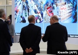 Russian President Vladimir Putin, accompanied by Prime Minister Mikhail Mishustin (right) and Moscow Mayor Sergei Sobyanin (left), tours a new coronavirus information center in Moscow on March 17.