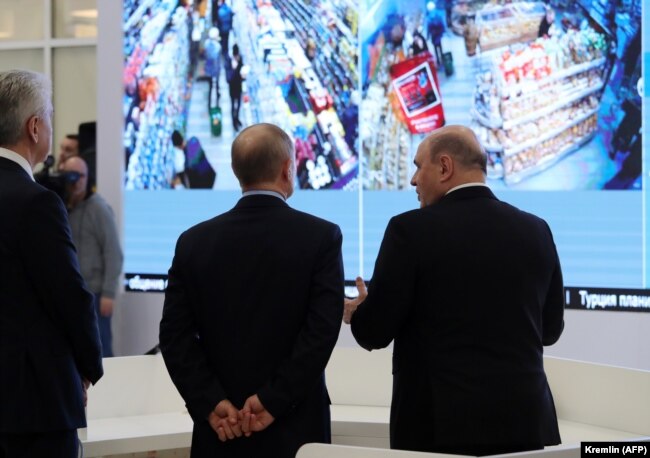 Russian President Vladimir Putin (center), accompanied by Prime Minister Mikhail Mishustin (right) and Moscow Mayor Sergei Sobyanin, tours the new coronavirus information center in Moscow on March 17.