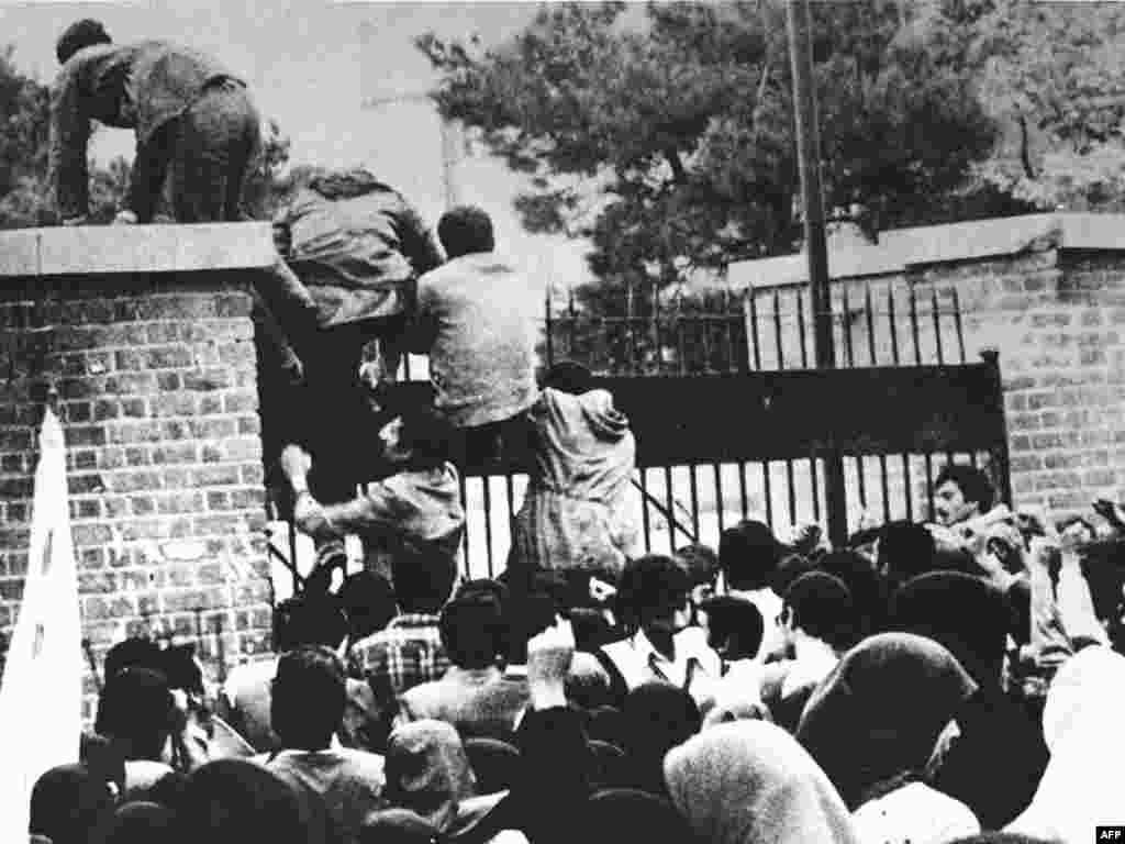 Iran -- Iranian students climb over the wall of the US embassy in Tehran, 04Nov1979 - IRAN, Tehran : (FILES) Iranian students climb over the wall of the US embassy in Tehran 04 November 1979. Twenty years later, 04 November 1999, the former embassy building now turns out officers of the Islamic Republic's Revolutionary Guards. 