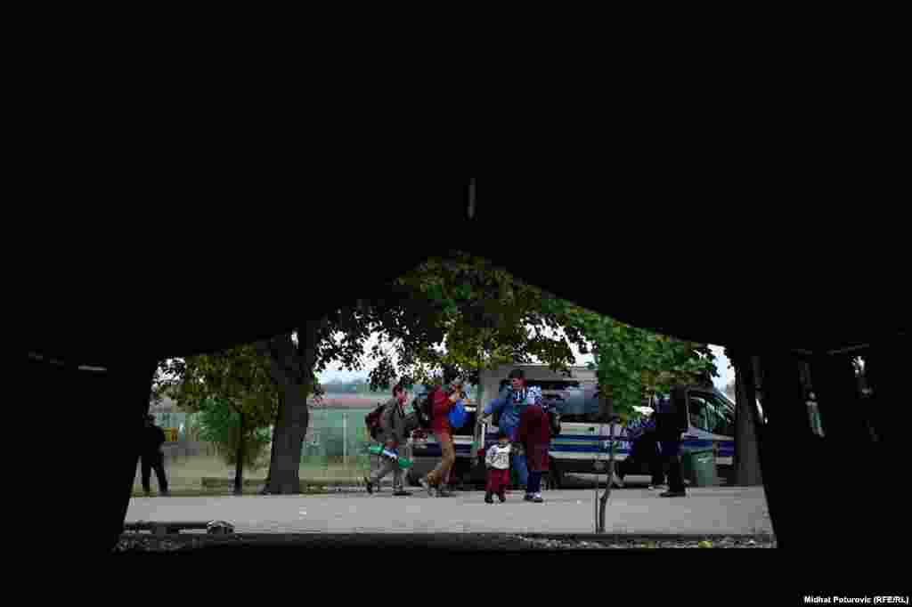 Pogled iz šatora na porodicu koja ide prema autobusu u prihvatnom centru u Opatovcu, pored grada Tovarnik u Hrvatskoj.Ovdje se vrši registracija izbjeglica koje su iz Srbije došle u Hrvatsku. Nakon registracije, izbjeglice nastavljaju put prema Sloveniji, većina izbjeglica želi da stigne u Njemačku.