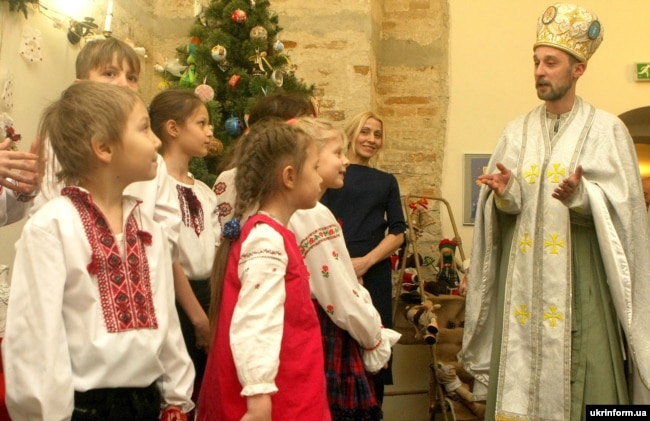 Діти біля чоловіка в образі святого Миколая під час урочистого відкриття святкової програми для дітей «Чудеса від святого Миколая». Київ, 16 грудня 2016 року