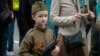 A young participant carries a toy gun in Sevastopol, Crimea, during the Immortal Regiment march on Victory Day, observed on May 9.