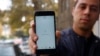 Iranac pokazuje telefon tokom prekida interneta u Teheranu, novembar 2019.