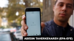 An Iranian man shows his phone during a disruption in Internet service in Tehran in November 2019.
