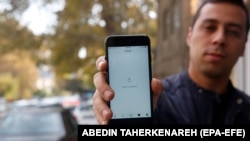 A man in Tehran shows his phone while unable to load a social media page amid an Internet shutdown in Iran.