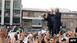 File - Presidential candidate Mir Hossein Musavi (R), speaks to his supporters during a massive rally on Tehran's Imam Khomeini square, June 18, 2009
