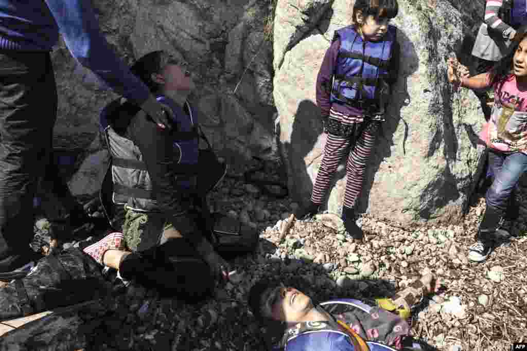 Female migrants and children from Syria take a rest as they arrive on a beach on the Greek island of Lesbos after crossing the Aegean Sea between Turkey and Greece on an inflatable boat with 35 other people. Some 124,000 people, almost all of them fleeing war and persecution in Syria, Afghanistan, and Iraq, have come ashore since the beginning of the year. (AFP/Achilleas Zavallis)