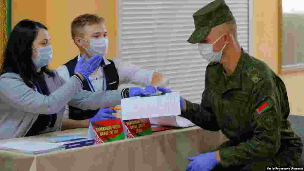 A Belarusian serviceman collects his ballot at a polling station.
