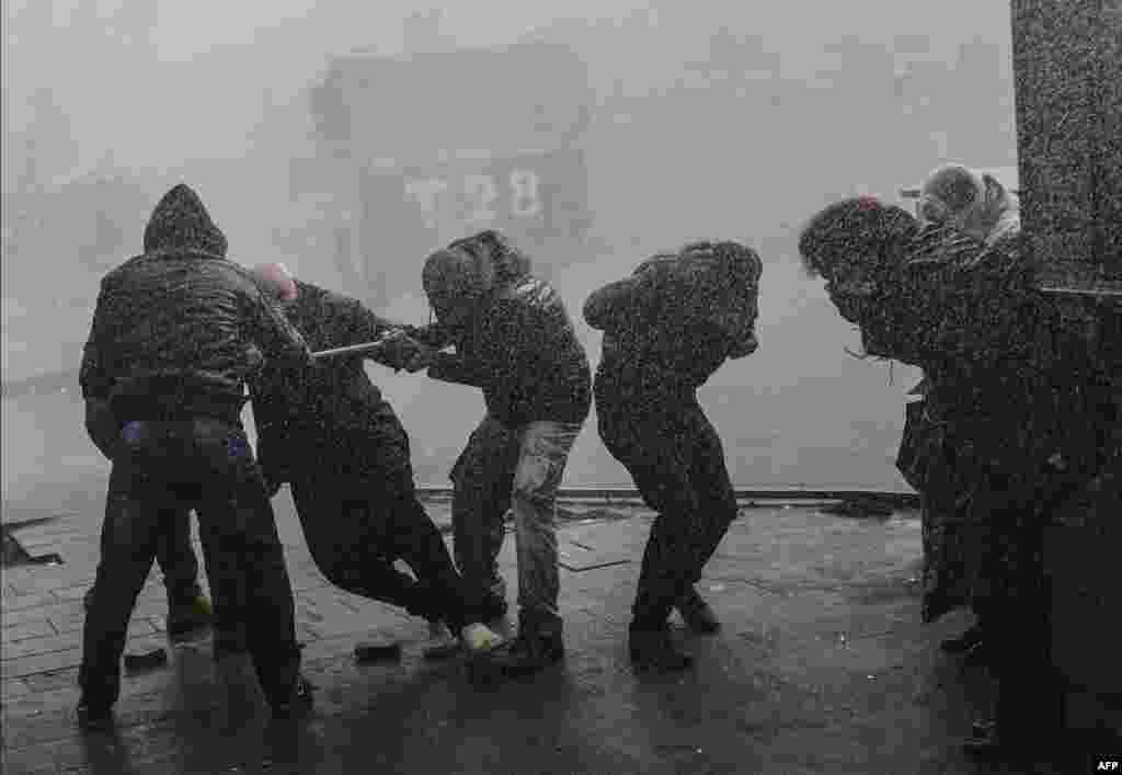 People run away from tear gas and water cannons as they protest against curfews on December 29 in the restive Turkish town of Diyarbakir on December 29. (AFP/Bulent Kilic)