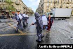 Muncitori care dezinfectează străzile din Baku, Azerbaidjan, drept măsură de prevenire a răspândirii pandemiei de coronavirus, 18 aprilie.