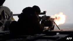 A Ukrainian Right Sector batallion volunteer fires a machine gun from his position near the eastern Ukrainian village of Pisky, in the Donetsk region, on January 3.