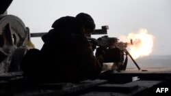 A Ukrainian Right Sector batallion volunteer fires a machine gun from his position near the eastern Ukrainian village of Pisky, in the Donetsk region, on January 3.