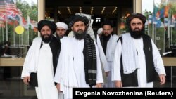 Members of a Taliban delegation, led by chief negotiator Mullah Abdul Ghani Baradar (center, front), leave after peace talks with senior Afghan politicians in Moscow on May 30.