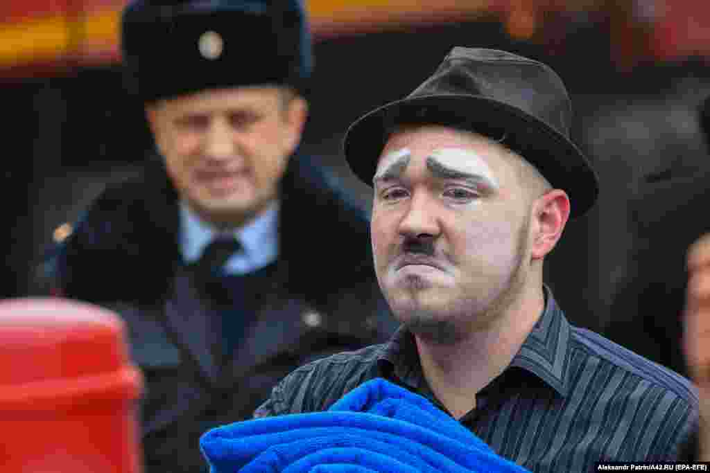 A man who was working as a clown watches recovery efforts outside the shopping center.