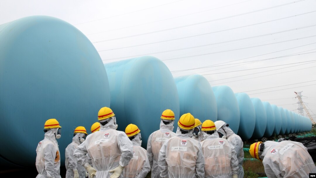 Japan Nuclear Regulation Authority (NRA) members are seen here wearing protective suits and masks while they inspect makeshift storage tanks.