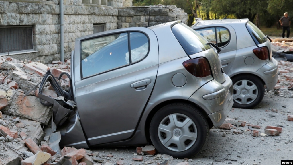 Destroyed cars stand next to a damaged building after an earthquake in Tirana on September 21.