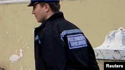 U.K. - Two police community support officers look at a piece of public art, depicting a sliding house in a residential road in Margate, southern England October 9, 2013. 