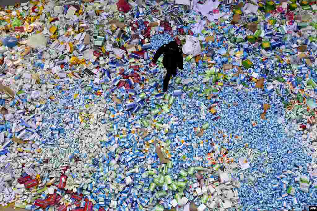 A Chinese policeman walks across a pile of fake medicines seized in Beijing in recent months. The rapid growth of Internet commerce has led to an explosion of counterfeit drugs sold around the world, with China the biggest source of fake medicines. (AFP)