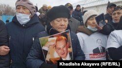 Активистка стоит с портретом Мухтара Джакишева у ворот колонии. Семей, 19 марта 2020 года.