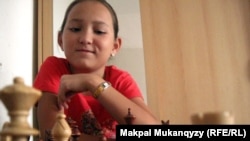 Жансая Абдумалик, трижды чемпион мира по шахматам среди детей, за шахматной доской. Алматы, 19 июля 2011 года.