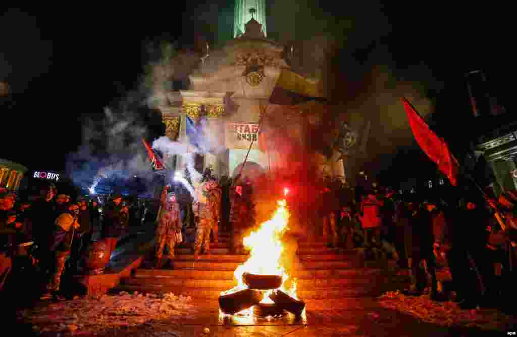 Activists and supporters of Ukrainian nationalist groups burn tires during a rally to mark the third anniversary of the Euromaidan Revolution on Independence Square in Kyiv on November 21 (epa/Roman Pilipey)