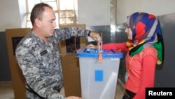 An Iraqi policeman casts his ballot during early voting for the parliamentary elections in Kirkuk on April 28.