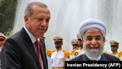 Iranian President Hassan Rohani (right) shakes hands with Turkish President Recep Tayyip Erdogan in Tehran on October 4. 