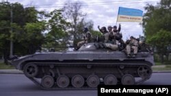 Украинские военнослужащие с флагом, на котором надпись на украинском языке: «Слава Украине! Смерть врагам!». Харьковская область, 16 мая 2022