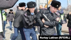 Полиция наразы азаматты көлікке күштеп салуға әкетіп барады. Алматы, 1 наурыз 2020 жыл.