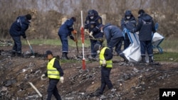 Dutch and Malaysian investigators work at the MH17 plane crash site near the village of Hrabove on April 16.