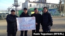 Группа активистов с плакатом возле тюрьмы, - в которой содержится оппозиционный политик Владимир Козлов, - с новогодним поздравлением Козлова. Второй слева - Марат Жанузаков, второй справа - Жасарал Куанышалин. Поселок Заречный Алматинской области, 28 декабря 2014 года. 