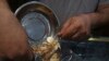 In this Wednesday, Aug. 12, 2018 photo, an Iranian goldsmith counts gold coins in the sprawling Grand Bazaar, that has seen customers eagerly buying gold as a hedge against the falling Iranian rial, in Tehran, Iran.