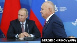 Russian President Vladimir Putin (left) and pro-Kremlin pundit Dmitry Kiselyov.