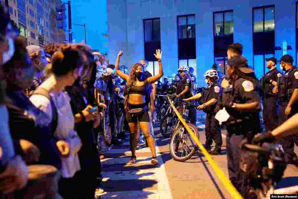 A demonstrator raises her hands during racial inequality protests near the White House in Washington, U.S., June 23, 2020. 