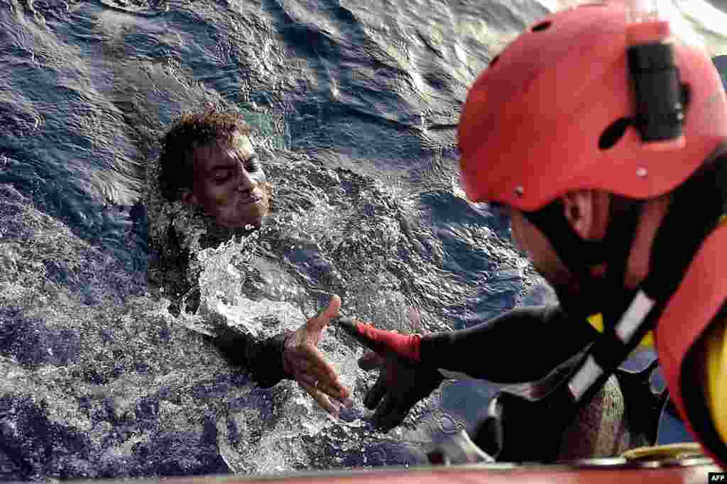 A migrant is rescued from the Mediterranean Sea by a member of the Proactiva Open Arms NGO some 20 nautical miles north of Libya. (AFP/Aris Messinis)