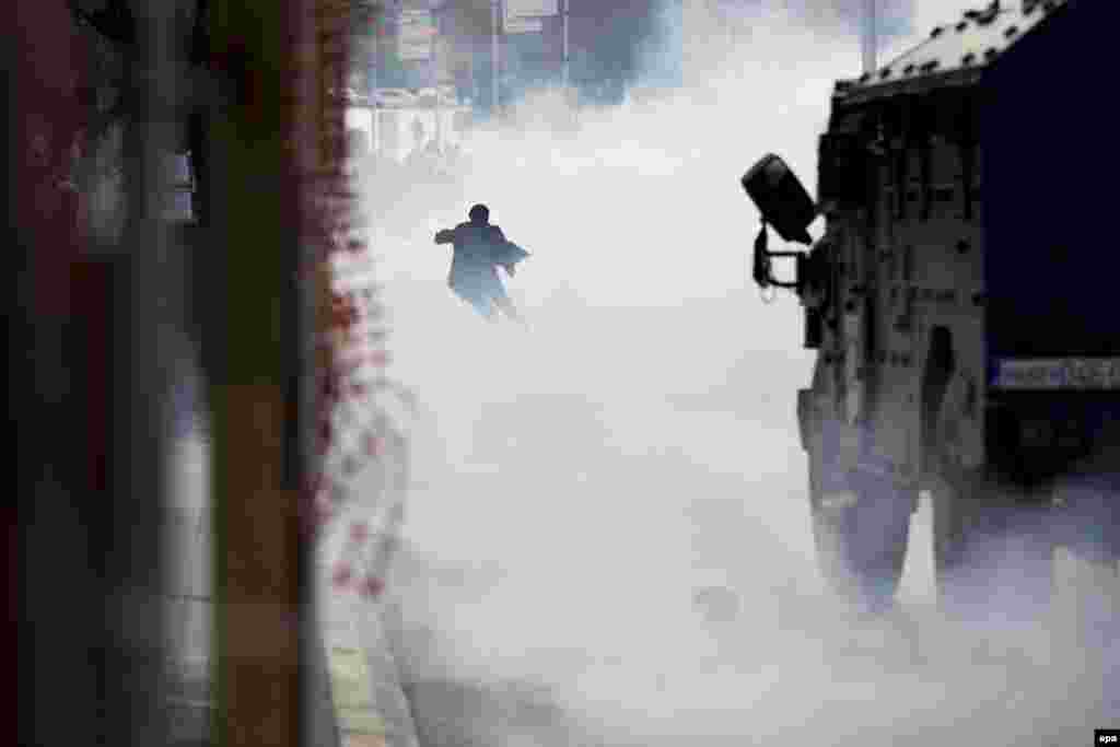 A supporter of Kosovo opposition political parties runs from tear gas during a violent protest in Pristina, Kosovo, on November 18, 2015. Kosovo Police used tear gas to disperse opposition supporters gathered to protest the arrest of an opposition lawmaker. (epa/Valdrin Xhemaj)